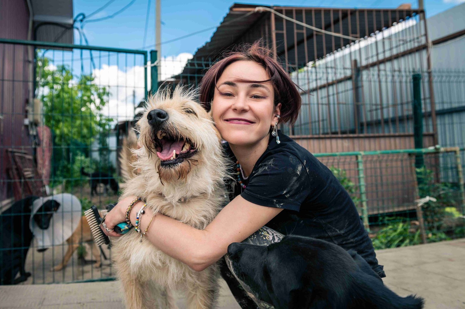 Female volunteer holding onto a dog in a warm, happy embrace